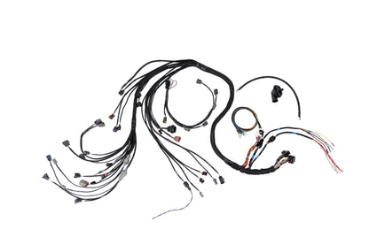 An automotive wiring harness kit with multiple black-wrapped cables, various connector types, and small black plastic components, laid out on a white background.